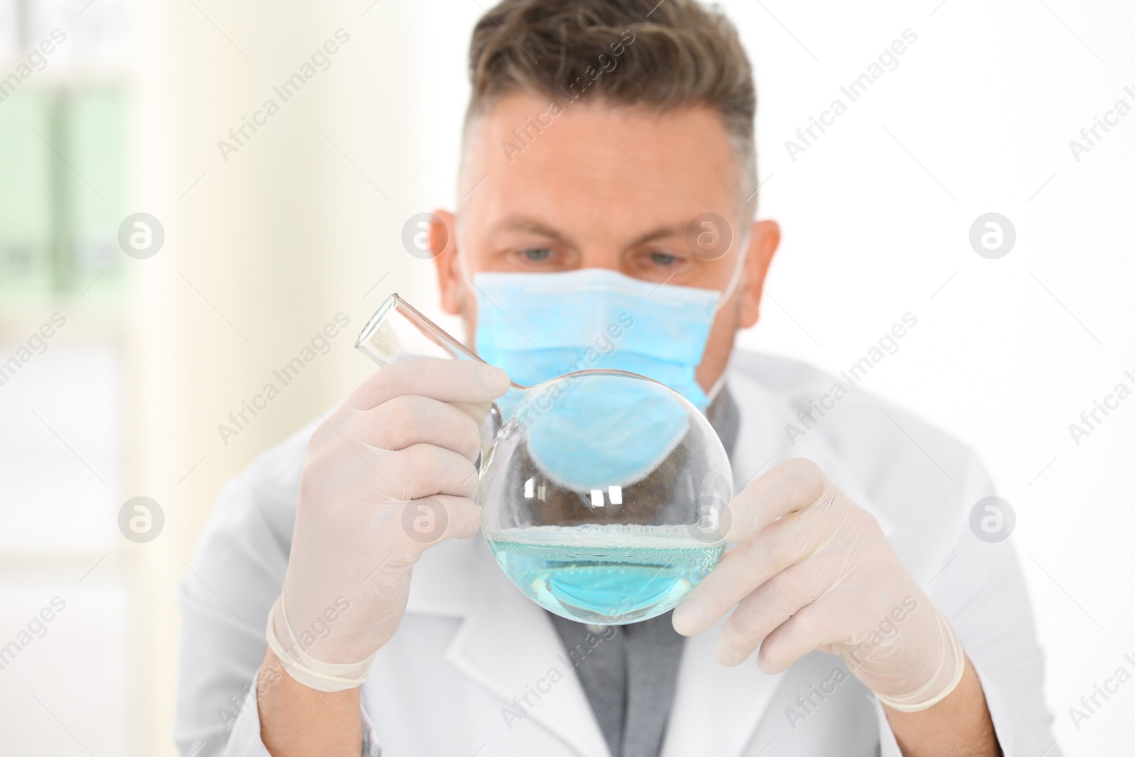 Photo of Male scientist with protective mask working in laboratory. Research and analysis