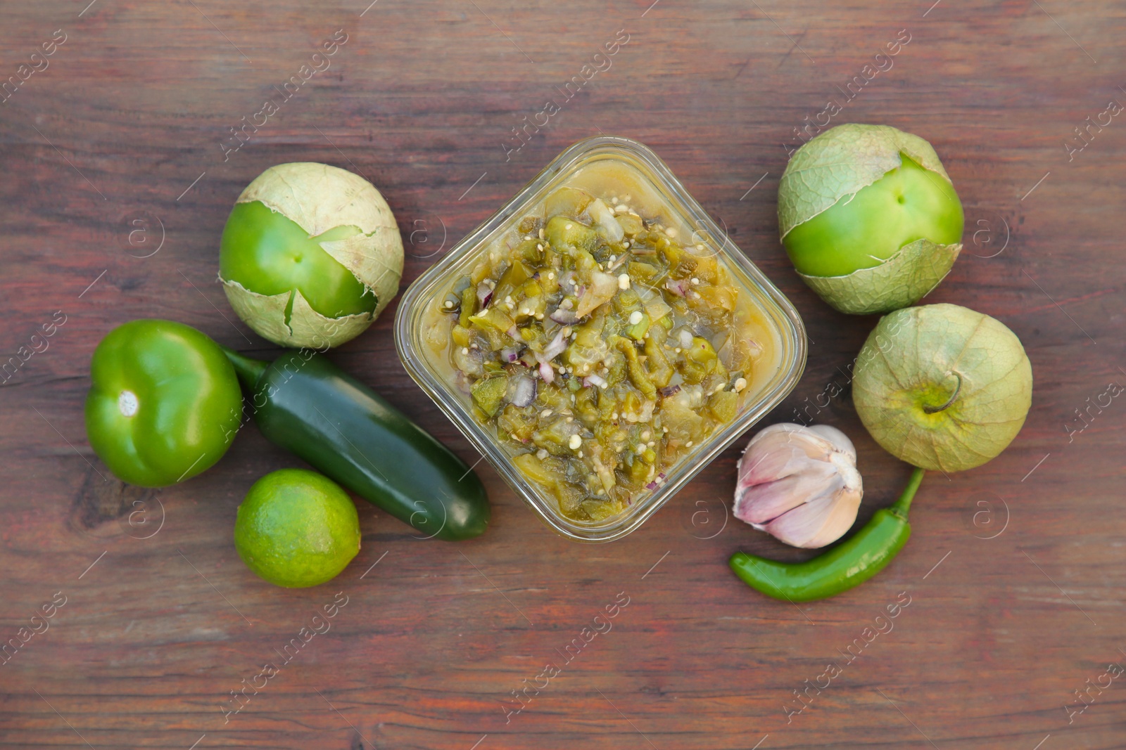 Photo of Tasty salsa sauce and ingredients on wooden table, flat lay