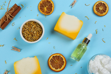 Photo of Flat lay composition with natural handmade soap and ingredients on light blue background