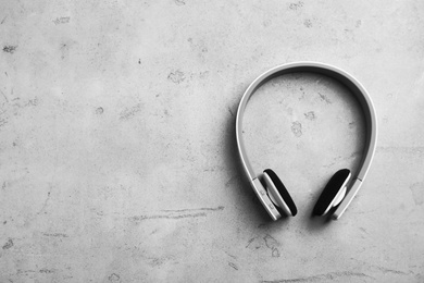 Photo of Stylish modern headphones and space for text on gray background, top view