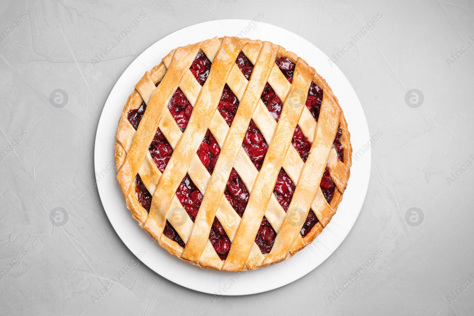 Photo of Delicious fresh cherry pie on light grey table, top view