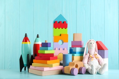 Set of different toys on light blue wooden table
