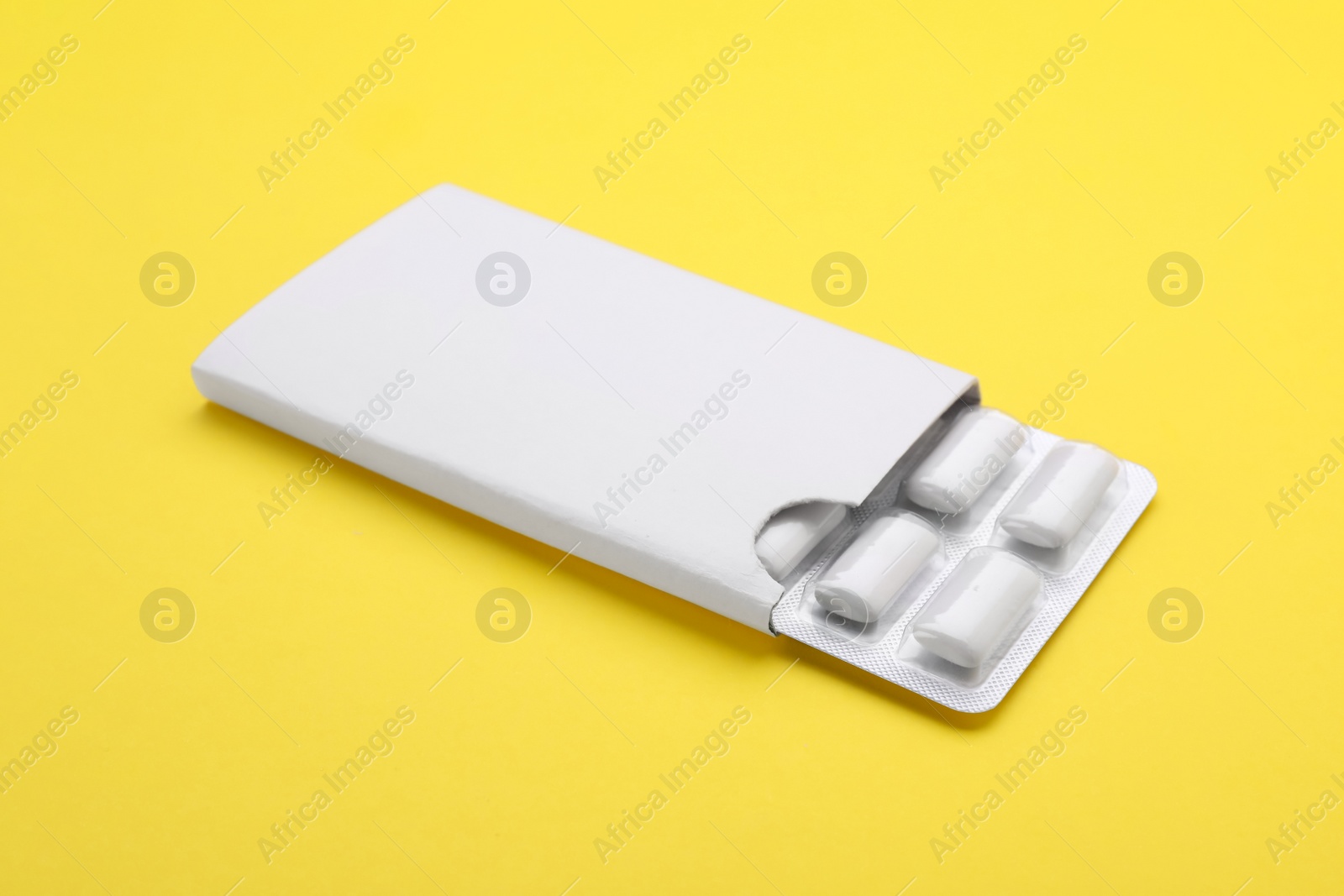 Photo of Blister with chewing gums on yellow background