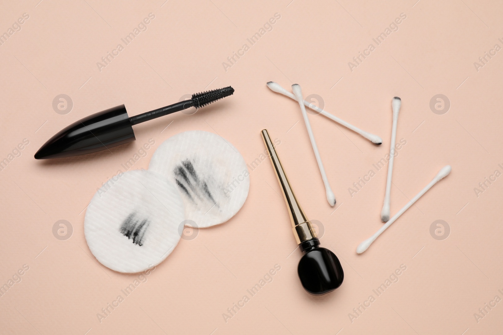 Photo of Dirty cotton pads after removing makeup, swabs and cosmetic products on beige background, flat lay