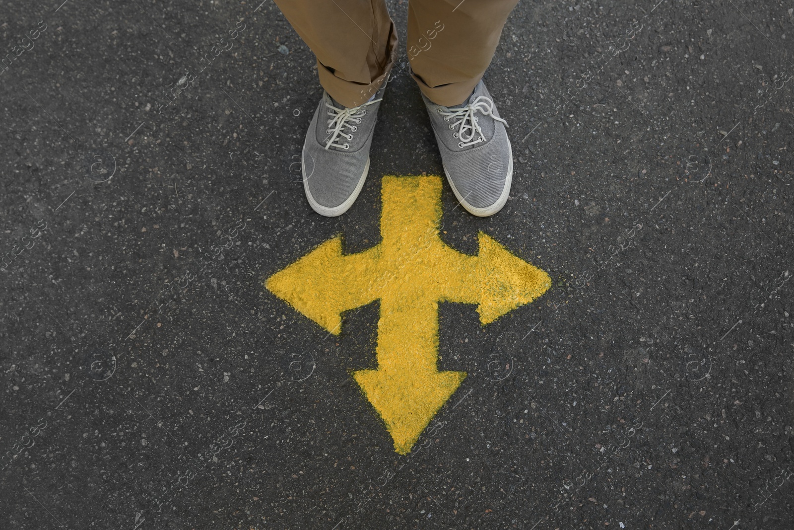 Photo of Man standing near arrow on asphalt, top view