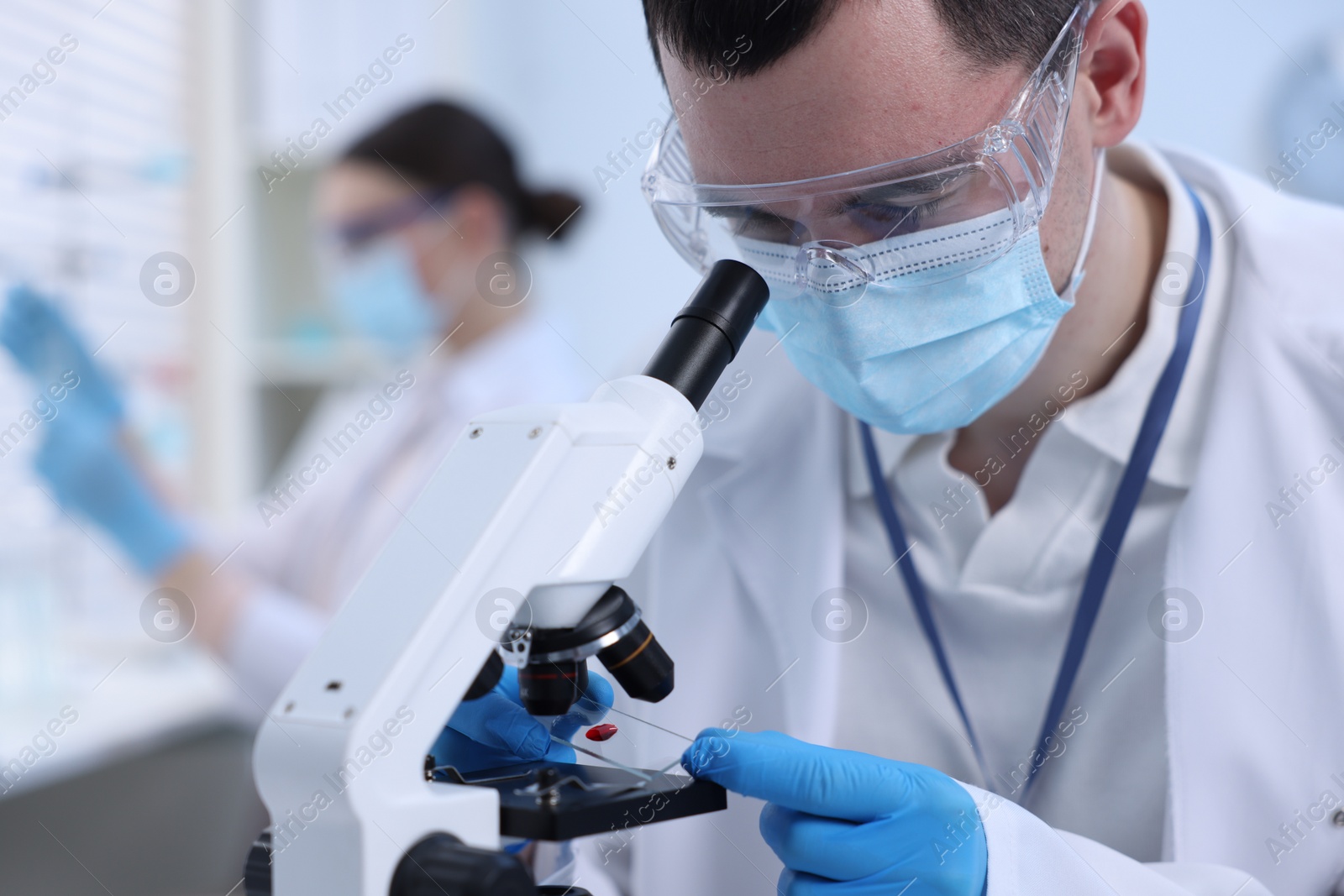 Photo of Scientist working with microscope in laboratory, closeup