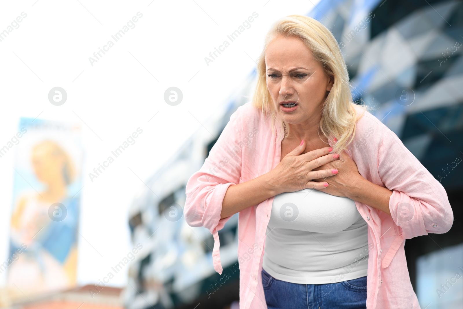 Photo of Mature woman suffering from heart attack outdoors. Space for text