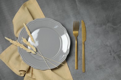 Photo of Stylish setting with elegant cutlery on dark grey table, top view