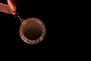 Photo of Bronze medal on black background, top view. Space for design