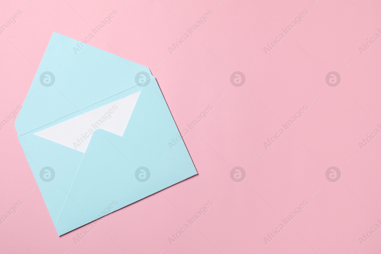 Photo of Letter envelope with card on pink background, top view. Space for text