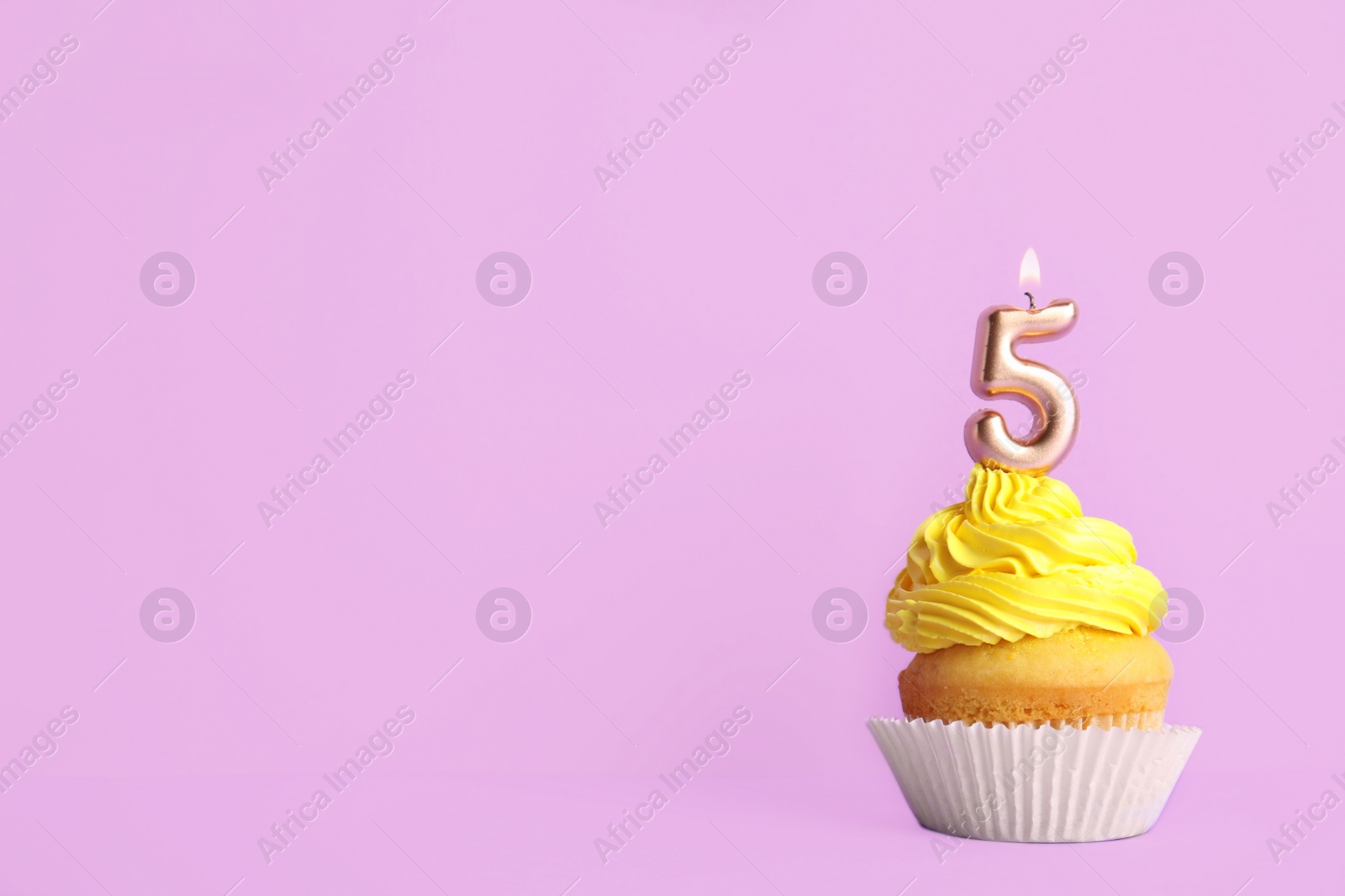 Photo of Birthday cupcake with number five candle on violet background, space for text