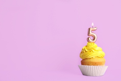 Photo of Birthday cupcake with number five candle on violet background, space for text