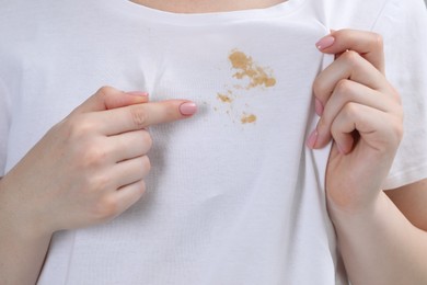 Photo of Woman showing stain on her t-shirt, closeup