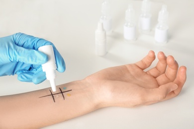 Doctor making allergy test at table, closeup