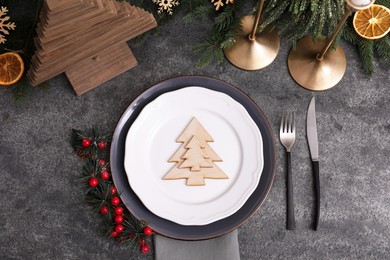 Photo of Festive place setting with beautiful dishware, cutlery and decorative tree for Christmas dinner on grey table, flat lay