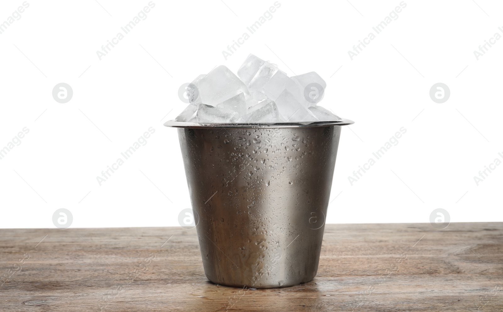 Photo of Metal bucket with ice cubes on wooden table against white background