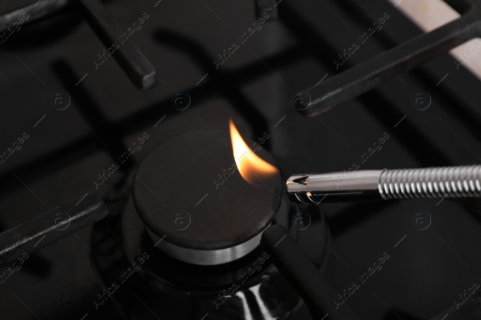 Photo of Lighting stove with gas lighter, closeup view