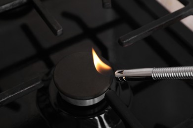 Photo of Lighting stove with gas lighter, closeup view