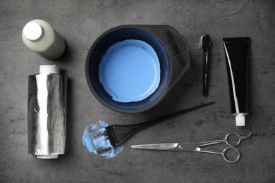 Photo of Professional tools for hair dyeing on grey stone background, flat lay