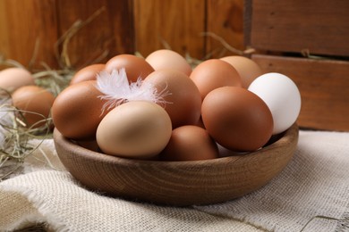 Photo of Fresh chicken eggs in bowl on table, closeup