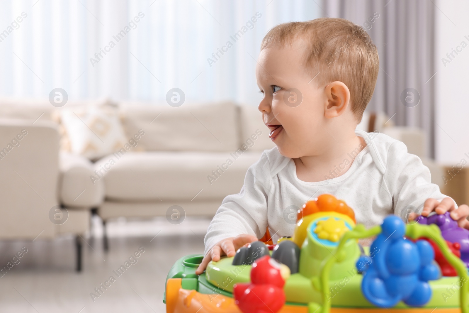 Photo of Cute little boy in baby walker at home, space for text