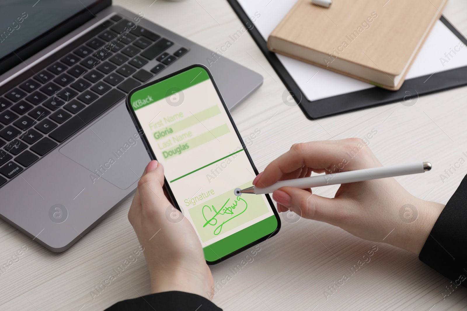 Image of Electronic signature. Woman using stylus and mobile phone at white wooden table, closeup