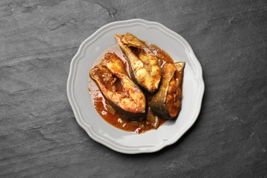Photo of Tasty fish curry on grey textured table, top view. Indian cuisine