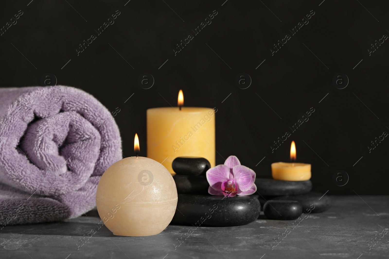 Photo of Composition with candles and spa stones on grey table