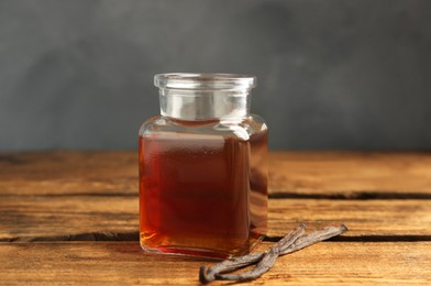 Aromatic homemade vanilla extract on wooden table