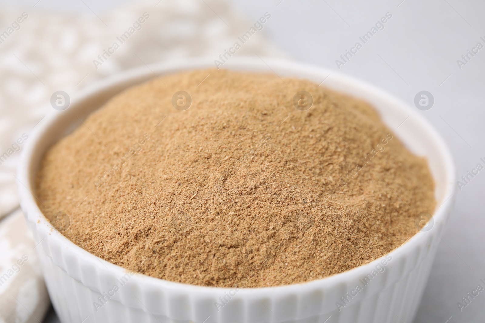 Photo of Dietary fiber. Psyllium husk powder in bowl on table, closeup