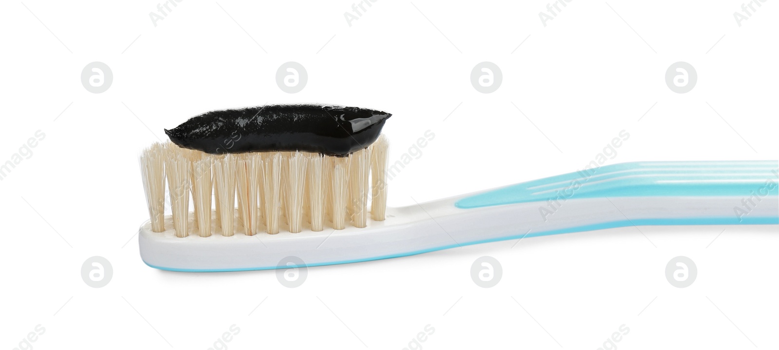 Photo of Natural bristle toothbrush with charcoal paste isolated on white