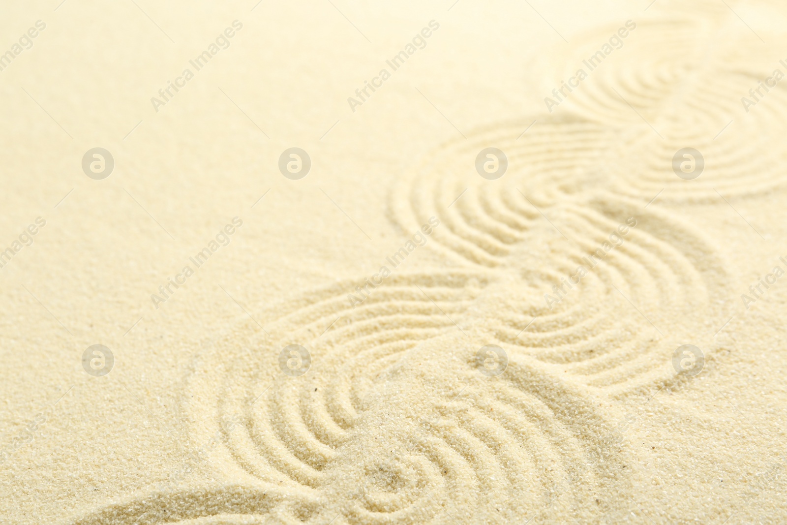 Photo of Zen rock garden. Wave pattern on beige sand