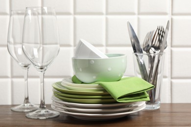 Photo of Beautiful ceramic dishware, glasses and cutlery on wooden table