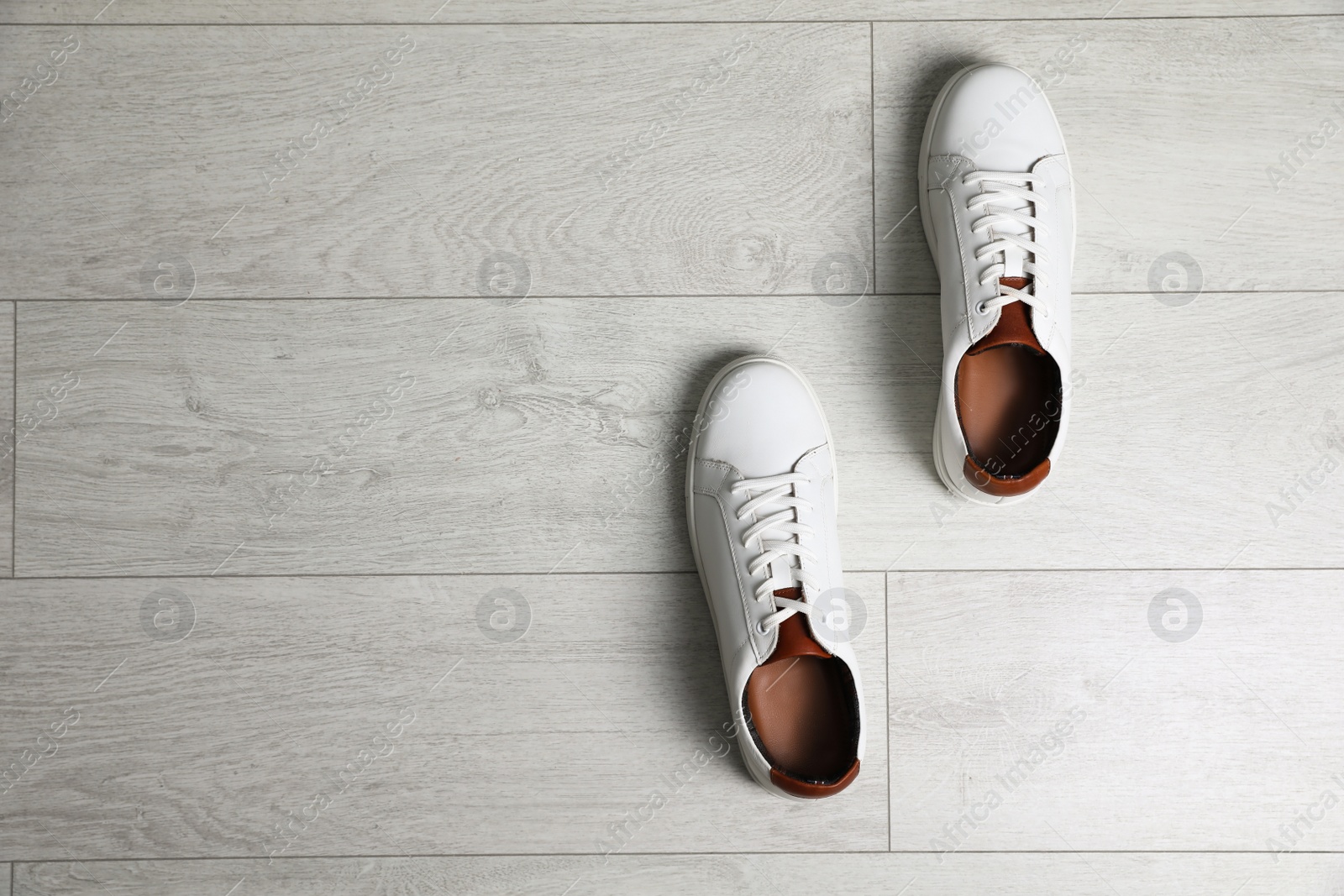 Photo of Pair of stylish sports shoes on white wooden floor, flat lay. Space for text
