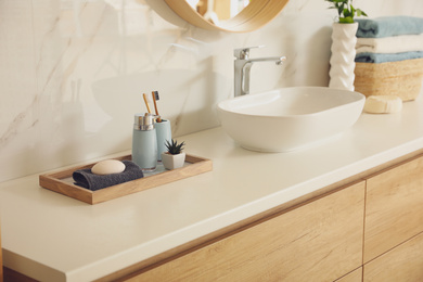 Countertop with sink and toiletries in bathroom. Interior design