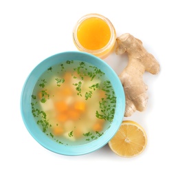 Photo of Bowl of fresh homemade soup to cure flu, lemon, ginger and honey on white background, top view