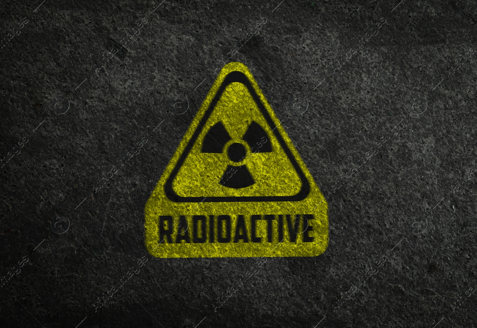 Image of Radioactive sign on grey stone wall. Hazard symbol