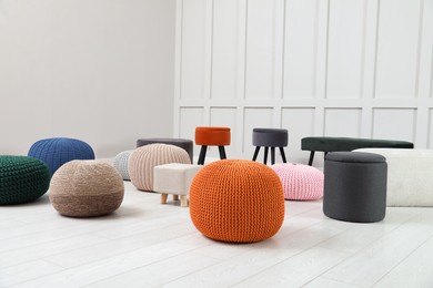 Different stylish poufs and ottomans in room