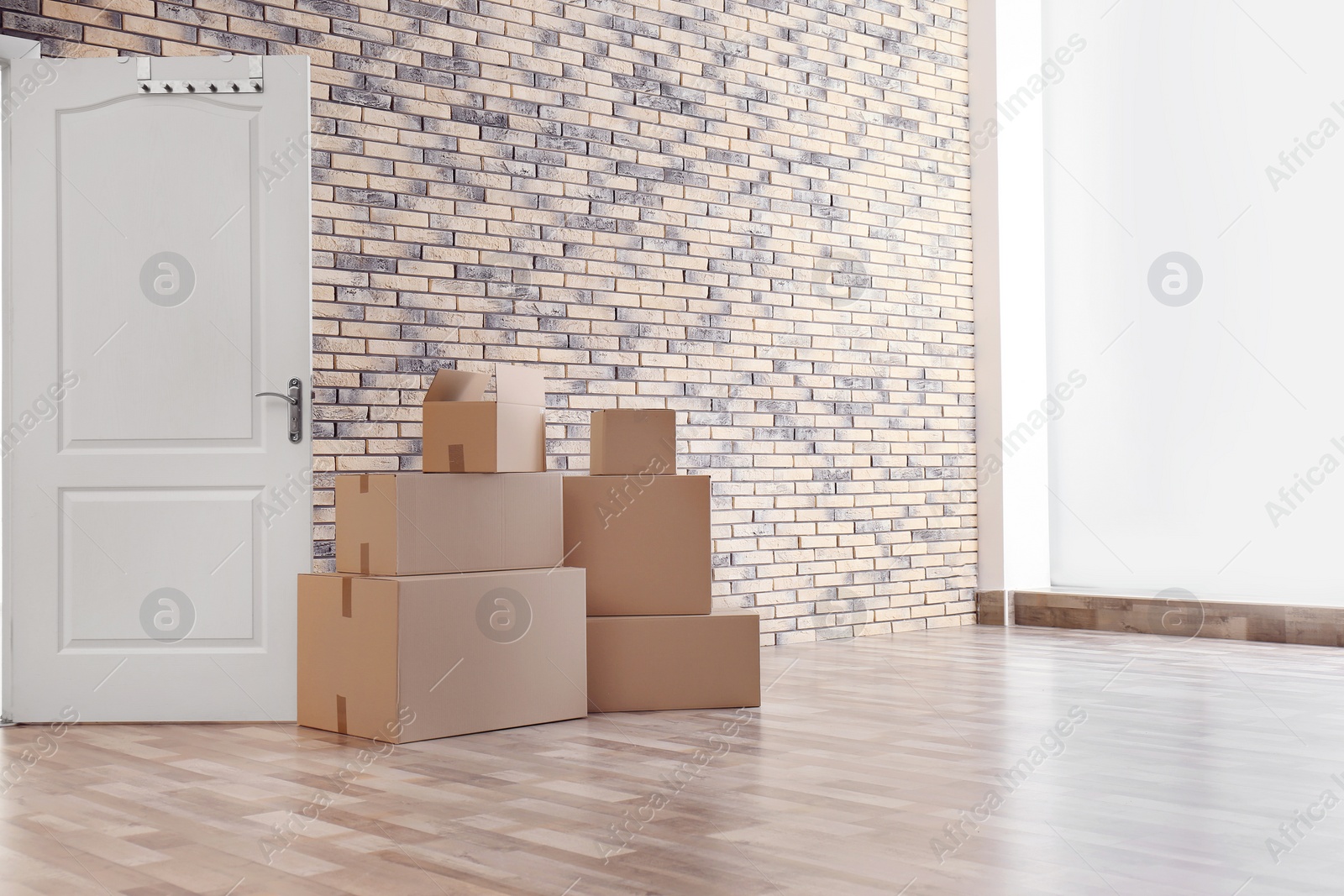 Photo of Pile of moving boxes in empty room