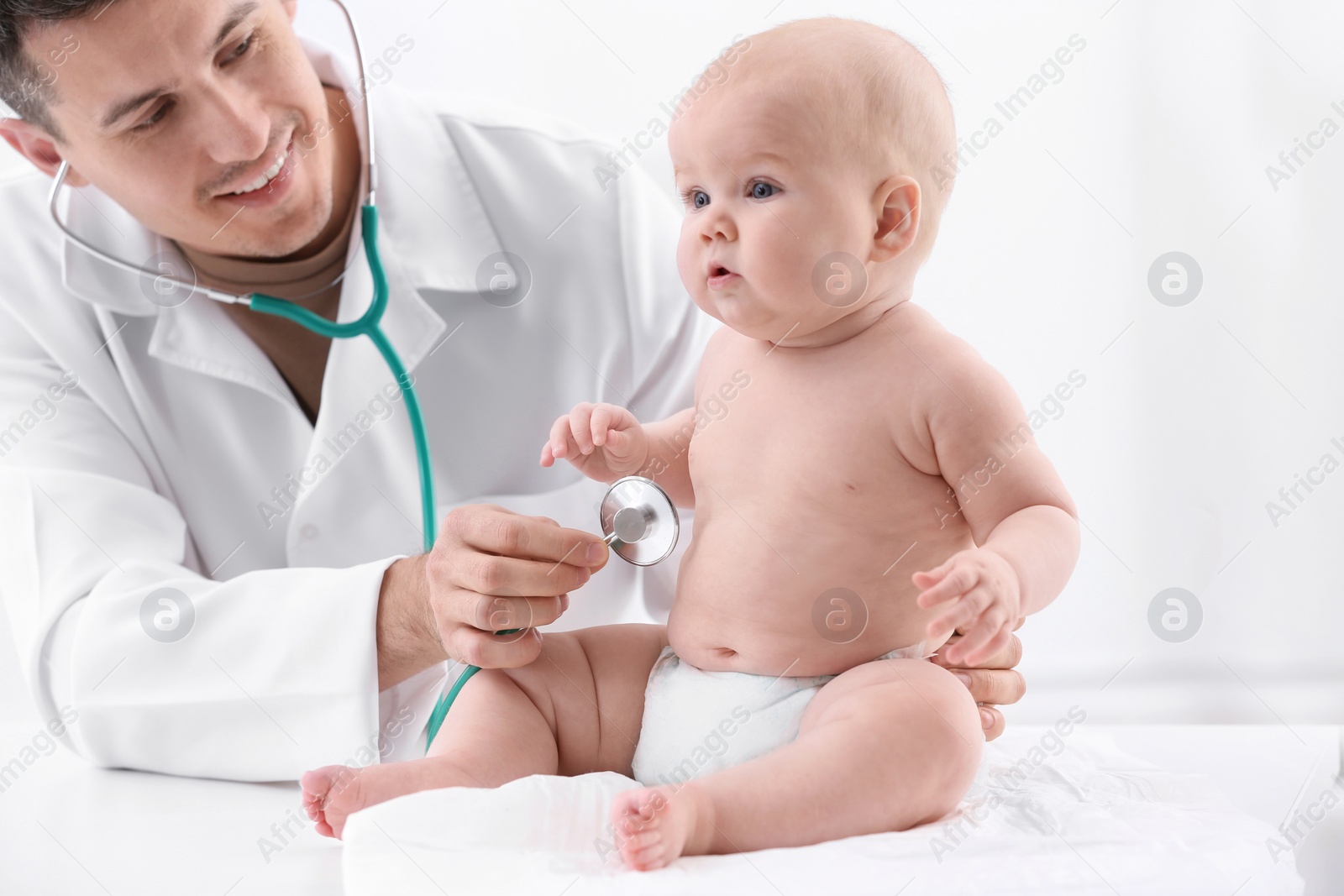 Photo of Children's doctor examining baby with stethoscope in hospital