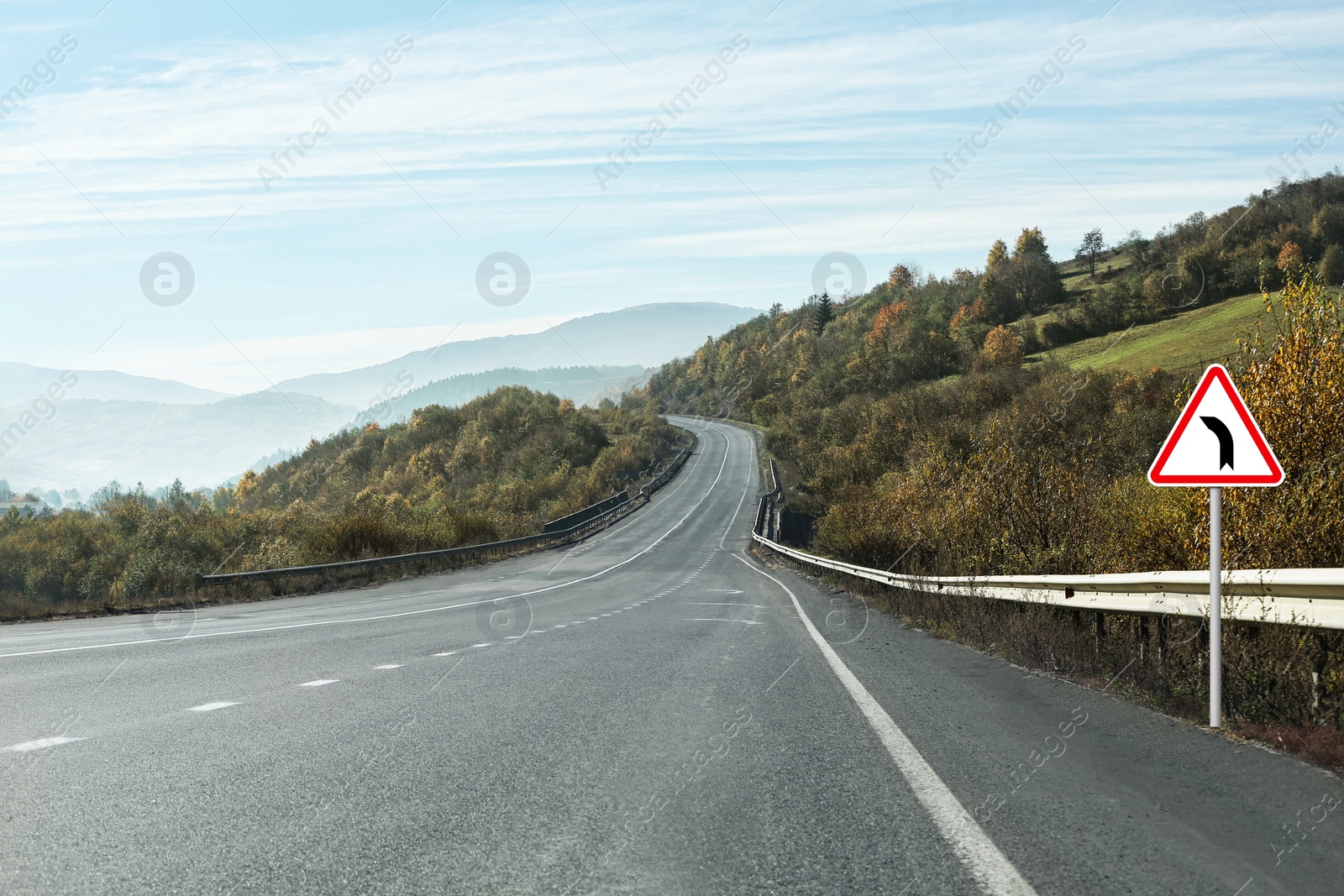 Image of Traffic sign BEND TO LEFT near empty asphalt road