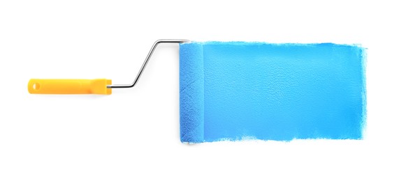 Photo of Roller brush with light blue paint on white background