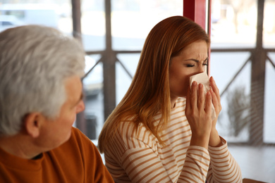 Sick woman with tissue indoors. Influenza virus