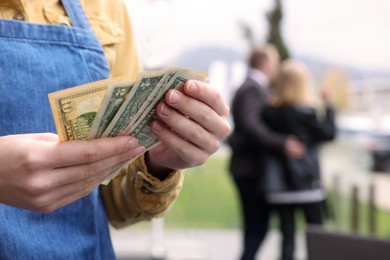 Photo of Waitress holding tips in outdoor cafe, closeup. Space for text