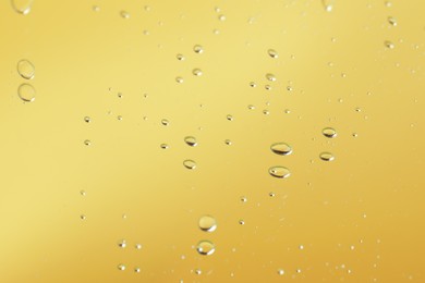 Photo of Many serum drops on mirror, toned in yellow