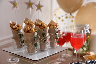 Delicious party treats on wooden table indoors