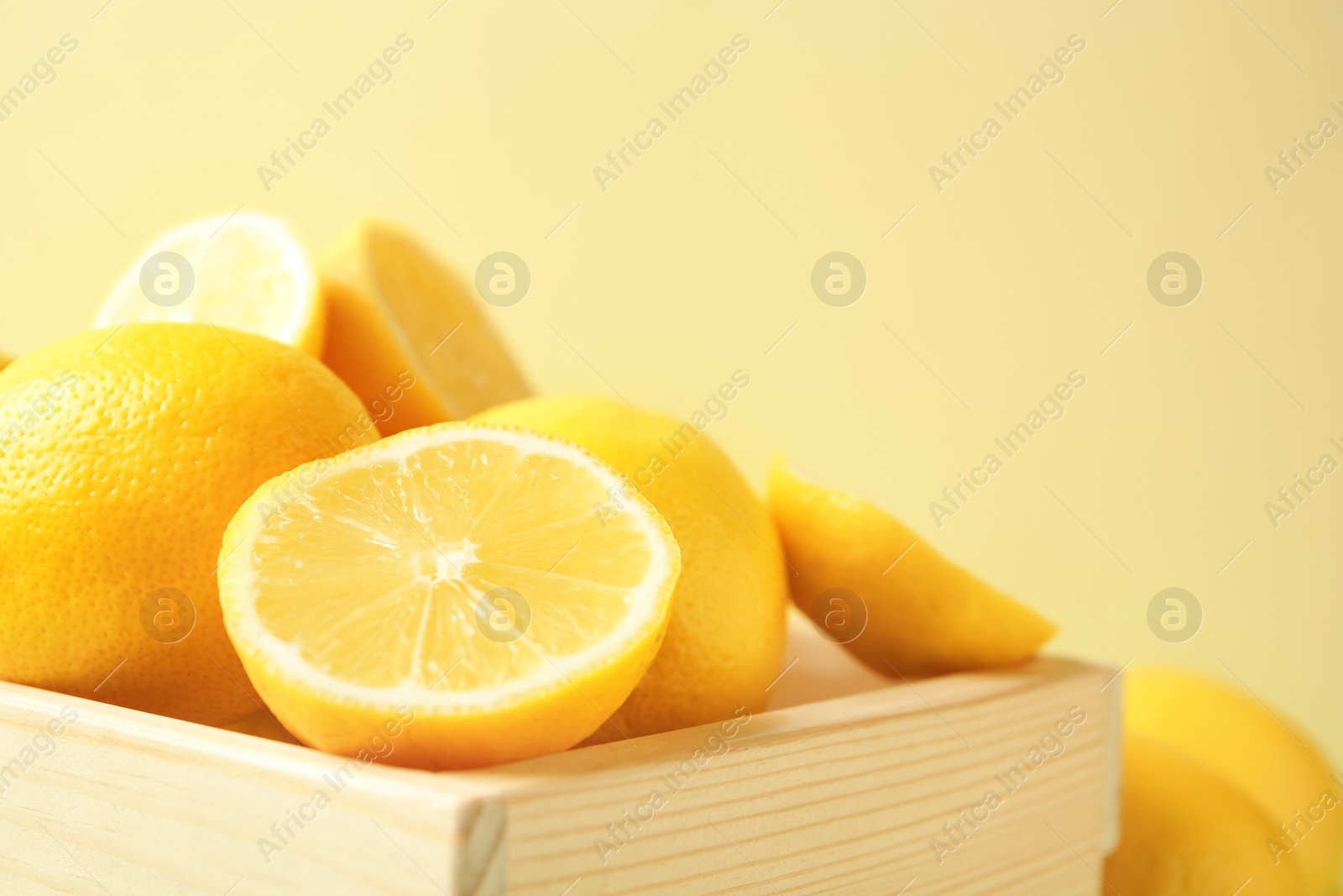 Photo of Wooden crate with fresh ripe lemons, closeup