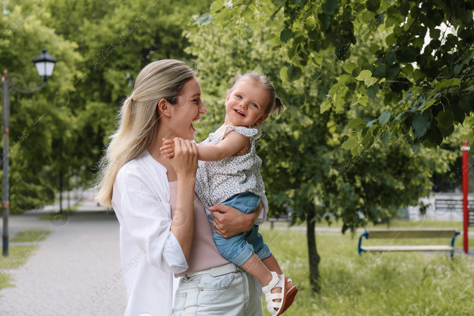 Photo of Happy mother with her daughter spending time together in park. Space for text