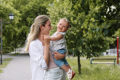Photo of Happy mother with her daughter spending time together in park. Space for text