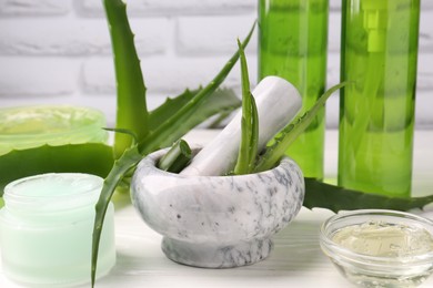 Homemade aloe gel and fresh ingredients on white wooden table, closeup